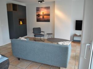 sala de estar con sofá y silla en Bungalow close to seaside resort De Koog en Westermient