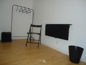 a room with a chair and a flat screen tv at Porta 86 in Cantanhede