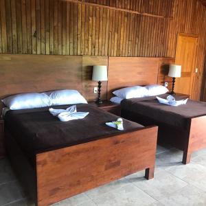2 Betten in einem Hotelzimmer mit Handtüchern darauf in der Unterkunft Tenamit Maya in El Higuerito