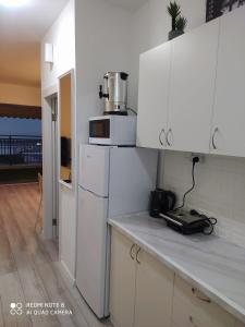 a kitchen with white cabinets and a microwave at סוויטה מול הים in Ashqelon