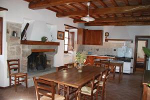 cocina y comedor con mesa y chimenea en Agriturismo Podere Fiume, en Pratovecchio