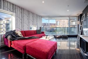 a living room with a red couch and large windows at Kira Kira Suites by H2 Life in Kutchan