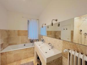 a bathroom with a tub and a sink and a bath tub at Wohnung Bel Etage im historischen Amtshaus in Fehmarn