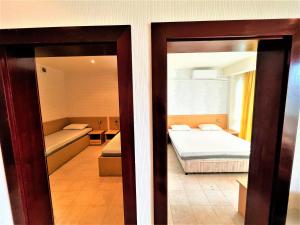 Habitación con vistas a un dormitorio con cama y espejo. en Miramar Front Beach Self Catering Apartments, en Sunny Beach
