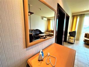 a hotel room with a table and a mirror at Miramar Front Beach Self Catering Apartments in Sunny Beach