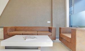 uma sala de estar com um sofá e uma mesa em Treebo Trend Grand Euro Pipliyahana Square em Indore