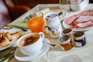a table with a cup of coffee and a plate of food at Albergo Alla Posta in Trieste