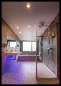 a large bathroom with a shower and a sink at Hotel Auberge St. Pol in Knokke-Heist