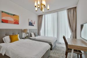 a hotel room with two beds and a desk and a table at Daniels 3BR with M Address JBR Dubai Eye View in Dubai