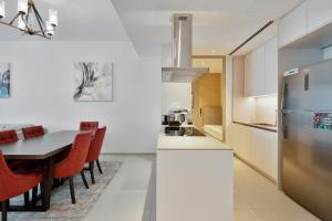 a kitchen and dining room with a table and a refrigerator at Daniels 3BR with M Address JBR Dubai Eye View in Dubai