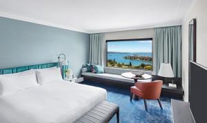 a hotel room with a bed and a large window at InterContinental Sydney, an IHG Hotel in Sydney