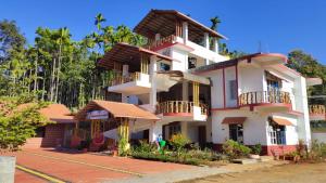 a large white building with balconies and trees at DELIGHTFUL HOMESTAY in Sollebail