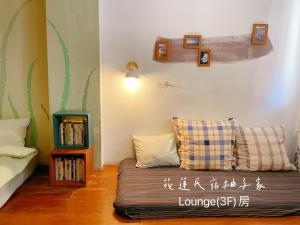 a living room with a couch and a bed at Yuzi Homestay in Hualien City