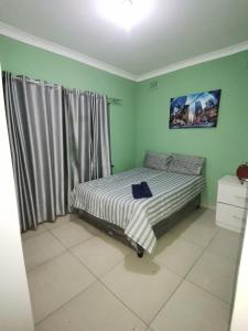 a bed in a room with a large window at Jackies Guest House in Durban