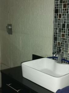 a bathroom with a white sink on a black counter at Jackies Guest House in Durban
