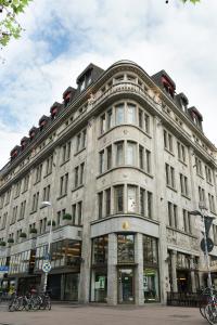 un grande edificio in pietra su una strada con biciclette parcheggiate di fronte di Central-Hotel Kaiserhof ad Hannover