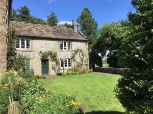 an old stone house with a large yard at Dunscar Farm Bed & Breakfast in Castleton