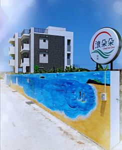 a building with a mural of the water in front of it at Lang duo duo Homestay in Huxi