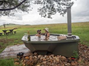 duas mulheres sentadas numa banheira num campo em Sibani Lodge - Glamping Tents em Krugersdorp
