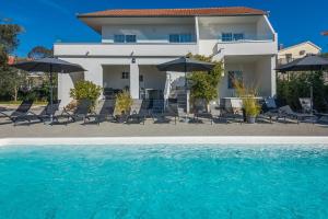 a house with chairs and umbrellas and a swimming pool at ROYAL CHOICE WITH POOL in Zadar