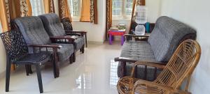 um grupo de cadeiras e mesas num quarto em The Pod Cochin Homestay em Cochin