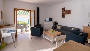ein Wohnzimmer mit einem Sofa und einem Tisch in der Unterkunft PuntBlanc Residences in Sant Elm