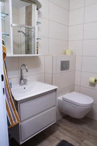 a white bathroom with a sink and a toilet at Studio-Appartement Drei Hörndl in Bad Hofgastein