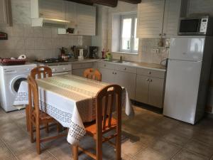 uma cozinha com uma mesa e um frigorífico branco em Gîte Laître-sous-Amance, 2 pièces, 3 personnes - FR-1-584-68 