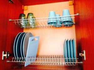 un estante con platos y utensilios en la cocina en A Cozy Central Studio, en Druskininkai