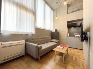 a living room with a couch and a table at PRISM INN OGU in Tokyo