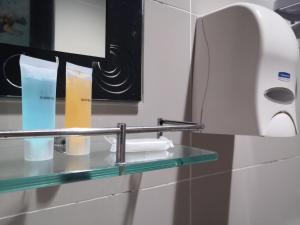a glass shelf in a bathroom with a toilet paper dispenser at Anggerik Garden Hotel - AG Hotel in Sitiawan