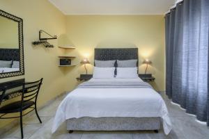 a bedroom with a large white bed and a desk at Ushaka Holiday Apartments in Durban