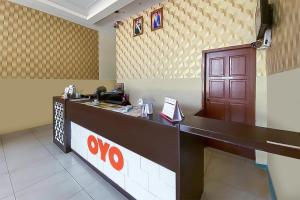 a waiting area of a restaurant with a cash counter at Super OYO 90385 H3 Hotel in Yong Peng