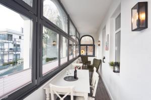 a dining room with windows and a white table and chairs at Haus am Meer Sellin App 5 und 6 by Meine Ferienzeit in Ostseebad Sellin