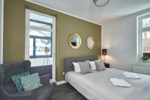 a bedroom with a bed and a chair at Haus am Meer Sellin App 6 by Meine Ferienzeit in Ostseebad Sellin