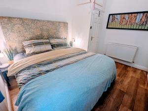 a bedroom with a large bed with a blue blanket at TopHome Highbury Apartment in London