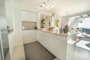 kuchnia z białymi szafkami i dużym oknem w obiekcie Holiday in ground floor apartment in Marbella Club Hills, Benahavis w mieście Benahavís