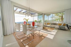 a living room with a glass table and chairs at Holiday in ground floor apartment in Marbella Club Hills, Benahavis in Benahavís