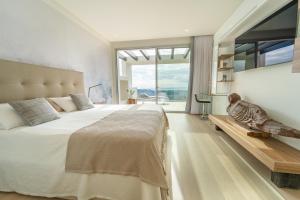 sypialnia z dużym łóżkiem i dużym oknem w obiekcie Holiday in ground floor apartment in Marbella Club Hills, Benahavis w mieście Benahavís