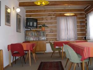 a dining room with tables and chairs and a tv at Pecka Penzion in Pec pod Sněžkou