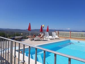 a woman sitting in chairs next to a swimming pool at Casa vacanze "La Caldosa" in Badesi