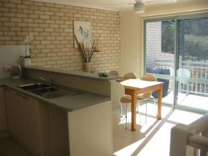 a kitchen with a sink and a table with chairs at Sandy Place on Long Beach in Long Beach