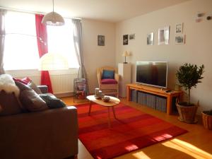 a living room with a couch and a television at Visavis Villa Velo in Jestädt
