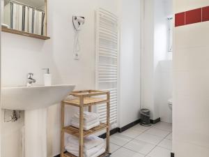 a white bathroom with a sink and a toilet at Le Gabriel in Strasbourg