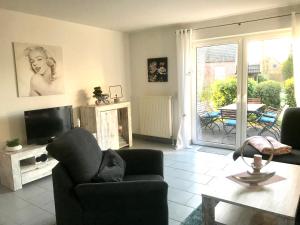 a living room with a couch and a tv at FeWo Lüttje Wooge Dornum in Dornum