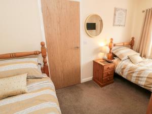 Un dormitorio con dos camas y un espejo. en Gough Bank, en Bridlington