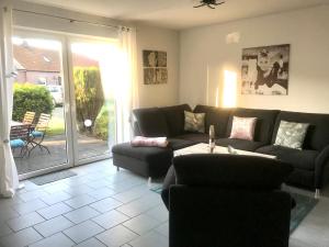 a living room with a couch and a table at FeWo Lüttje Wooge Dornum in Dornum