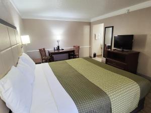a hotel room with a bed and a table and a television at Flex Studios in San Antonio