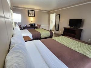 a hotel room with two beds and a flat screen tv at Flex Studios in San Antonio