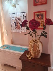 eine Vase mit roten Rosen auf einem Tisch in der Unterkunft Casamia - 2 camere da letto in Alba Adriatica